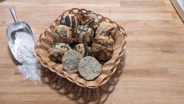 This picture showes franconia buns with different sort of seeds in a basket such as sesame, sunflower, pumpkin and poppy seeds
