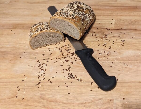 this picture shows the oil seed bread cut in half with a knife underneath