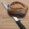 This picture shows the rustic country bread 600gr with a knife underneath