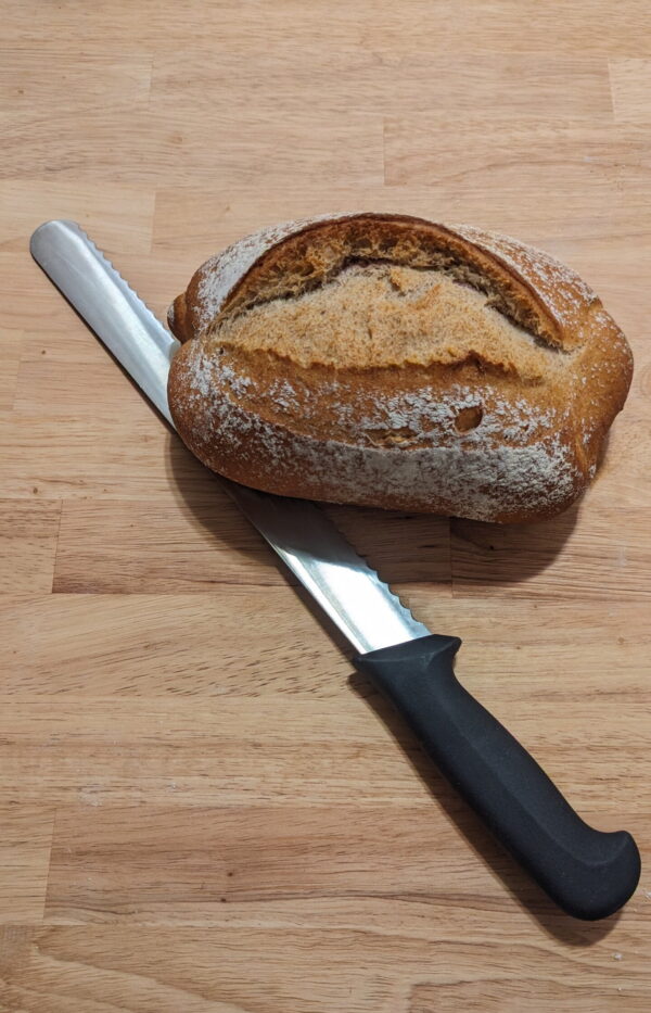 This picture shows the rustic country bread 600gr with a knife underneath