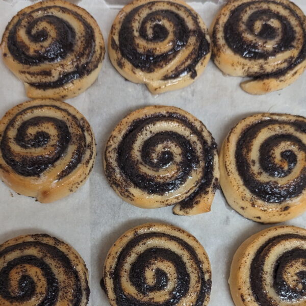 This picture shows multiple poppy seed swirls on a baking tray
