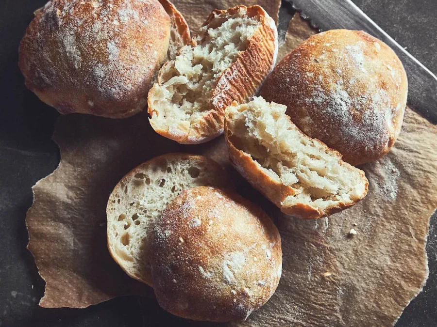 This image shows our sourdough ciabatta buns on a cutting board, show casing the nice texture of the bun