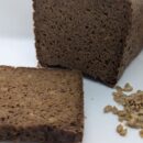 Deep-Earth-Rye-Black-Bread Freshly baked deep earth rye black bread (pumpernickel) with a rich, dark color and dense texture, made with 100% rye flour and sunflower seeds for a hearty, flavorful taste