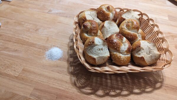 a basket of bretzel buns and knots on a table